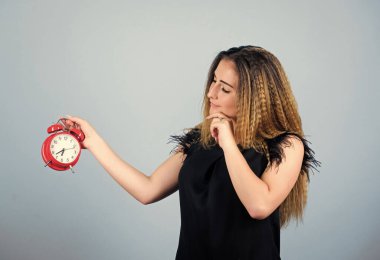 Zaman ve yaş kavramı. Günaydın. Kadının geç kalması. İş için son gün. Zaman yönetimi. Zaman dilimi. Dakiklik ve disiplin. Kız çalar saati tutuyor. Rejim erken uyanma. Zil çalıyor.