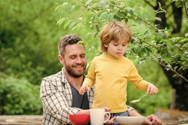 Aile yemeği zamanı. Yaz pikniği. Sabah kahvaltısı. Sağlıklı yemek ve diyet. Çocuklar Günü 'nde. Babalar günün kutlu olsun. Babasıyla küçük çocuk mısır gevreği yiyor. Baba oğul dışarıda yemek yiyorlar. Sadece etrafta olmak