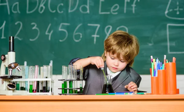 En vetenskapsman som studerar naturvetenskap. Laboratorieutrustning för biologiska skolor. En liten pojke på lektionen. Tillbaka till skolan. En liten pojke i grundskolan. Små barn lär sig kemi. Stressad trött läkare — Stockfoto