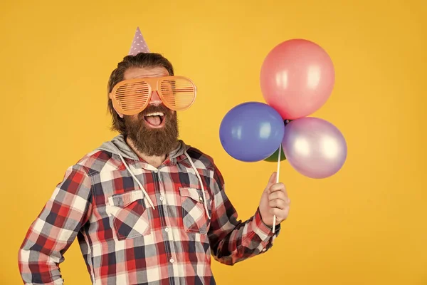 İyi görünüyorsun. Doğum günü şapkalı komik adam. Mutlu bayramlar. Partiye gidenler çıldırıyor. Balonlarla eğleniyorum. Yıldönümü için hazırlanın. En iyi etkinlik yöneticisi. Vahşi erkek partide. — Stok fotoğraf