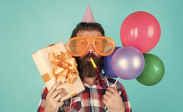 Nach dem Einkaufen. Feiern fröhliche Party. Party-Elemente und Ferienobjekte. Bunten Spaß. beste Party für den Ruhestand. Ein fröhlicher Mann mit Bart hält Gegenwart. Hipster lächelt mit Luftballon — Stockfoto