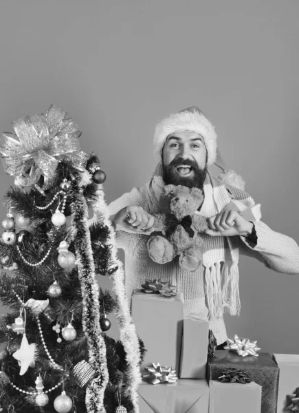 Guy en chapeau rouge avec boîtes cadeaux de Noël et ours — Photo