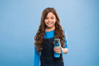 Biraz sıvı iç. Su dengesi kavramı. Güçlü ve sağlıklı bir çocuk. Sağlıklı bir hayat. Sağlık ve su dengesi. Kızın elinde su şişesi var. Uzun saçlı çocuğun su şişesi var.