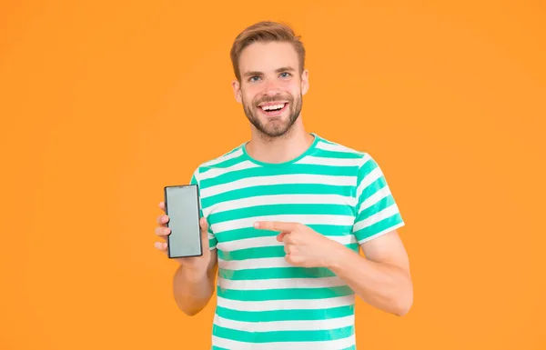 Servizi mobili. Internet gratis. Smartphone applicativo. Scaricare e iniziare a giocare. Un uomo che indica uno smartphone. Un gesto pungente. Indica il dito indice. Indicazioni per la pubblicità. Tecnologia digitale — Foto Stock