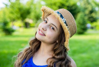 Güneş kremi ve güneş şapkası tak. Mutlu kız yaz manzarası gülümsüyor. Pediatrik cilt rutini. Doğal cilt bakım ürünleri. Güzellik bakışı. Cilt bakımı