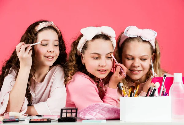 Beautiful female. friendship and sisterhood. family bonding time. childhood happiness. retro kids put on makeup. skin care cosmetics for children. beauty and fashion. three happy girls at hairdresser