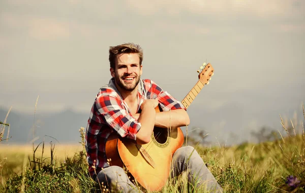 La música es la respuesta. vaquero con guitarrista acústico. moda hipster. feliz y libre. sexy hombre con guitarra en camisa a cuadros. camping occidental y senderismo. música country canción — Foto de Stock