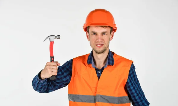 Joven trabajador es ingeniero asistente. Reparador de uniforme. hombre trabaja con martillo. verdadero trabajador de la construcción en casco. carpintero listo para trabajar. equipo de reparación de herramientas de construcción. Le encanta su trabajo. — Foto de Stock