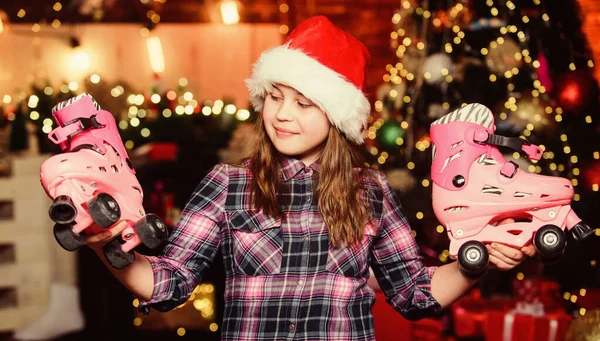 Feliz año nuevo concepto. Los sueños se hacen realidad. Tengo un regalo que quería. Un chico cerca del árbol de navidad sostiene patines. Chica satisfecha regalo de Navidad. Regalo de Navidad con el que soñaba. El mejor regalo de todos —  Fotos de Stock