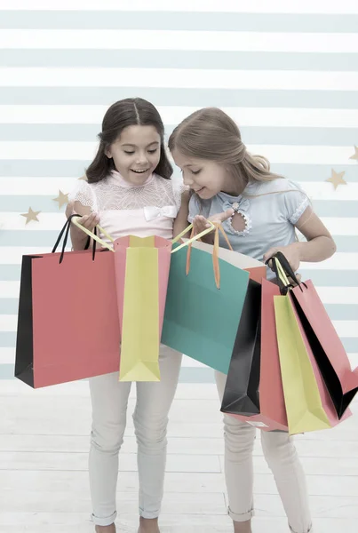 Viernes negro en el mercado escolar. niñas niños pequeños felices con bolsas de compras después de la venta de viernes negro. niños pequeños con compra en el mercado escolar. —  Fotos de Stock