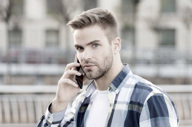 Akıllı telefonlu bir adam. Açık havada kıllı, şık, genç bir adamın portresi. Sıradan, kareli gömlek giyen bir adam. Çevik iş. Modern hayat öğrencileri. Taksi çağır. Kendinden emin ve seksi.