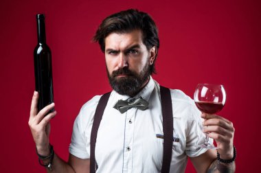 Şarap üreticisi şişeden kırmızı şarap kadehi, elit alkol içeceği sunuyor.