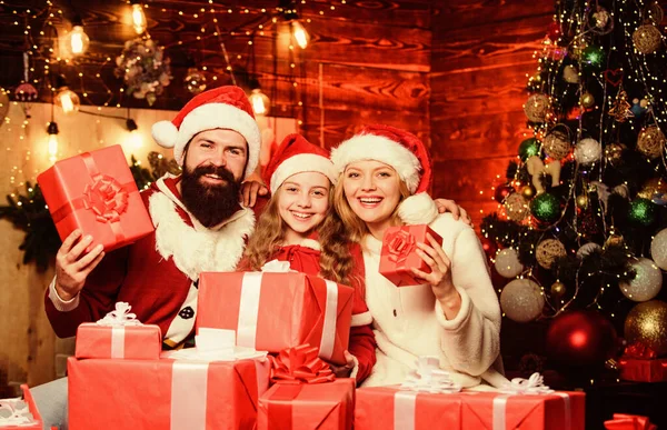 Gåvor från tomten. Bryr sig om de närmaste. Samhörighetskoncept. Kärlek och vänlighet. Fader Jultomten kostym med familj firar jul. Härlig dotter med föräldrar bär Santa hatt — Stockfoto