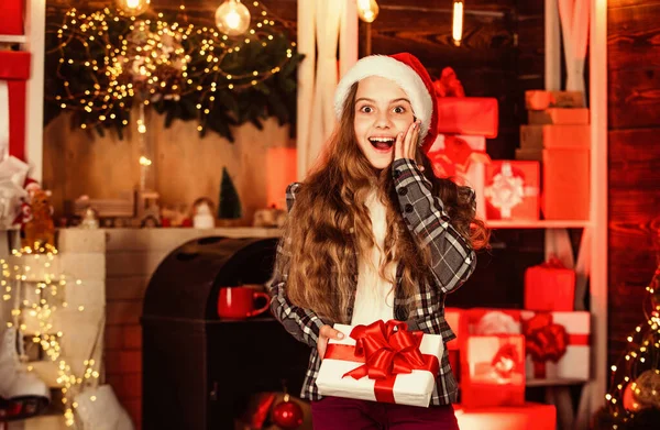 Felice anno nuovo 2020. Ragazzo allegro col cappello da Babbo Natale. regali e regali shopping. Camera decorata per Natale. La bambina festeggia Natale. composizione natalizia. decorare la vostra casa e albero di Natale — Foto Stock