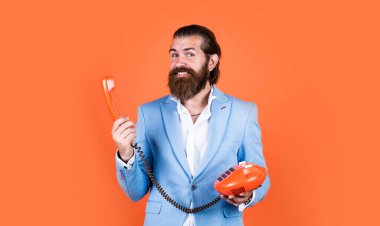 Vintage telefonla konuşan bir adam. Elinde retro telefon tutan takım elbiseli sakallı bir adam. Bağlantıda kal. Müşteri hizmeti konsepti. Telefon ahizeli sakallı adam. İş görüşmesi konsepti. daha yüksek emlak biçimi