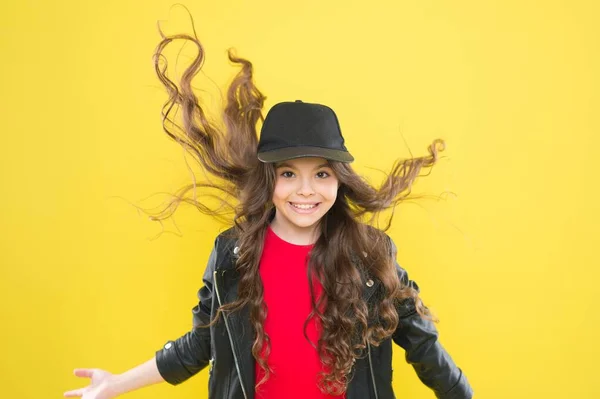Feeling good fabulous hair. Happy child with long wavy flowing hair. Beauty salon. Haircare cosmetics. Hairdressing and beauty therapy. Shampooing and conditioning. Styling and twisting