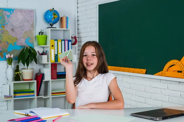 Excited about knowledge. kid in classroom with chalkboard. child hold paper plane. back to school. formal education in modern life. home schooling. childhood development. get knowledge through study — Stock Photo, Image