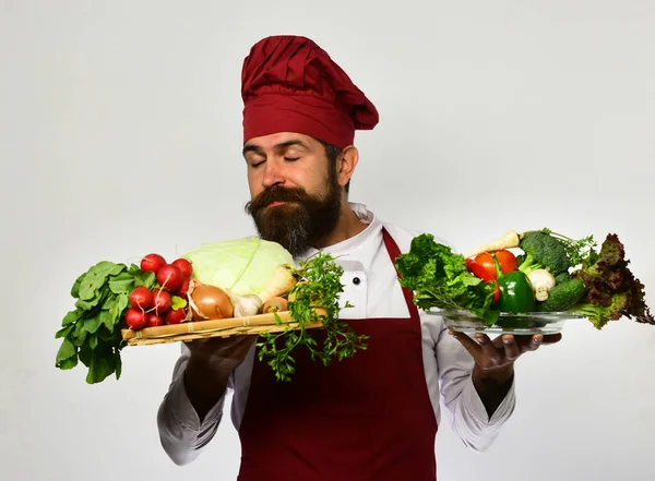 Cooking and vegetarian diet concept. Chef holds board with vegetables