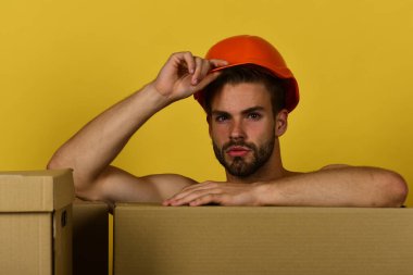 Çıplak elleri olan adam kutuların arkasında duruyor, boşluğu kopyala.