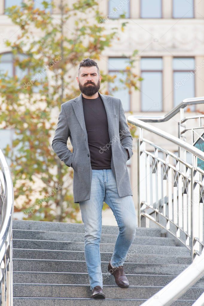 confident male businessman in casual business fashion jacket walk in street having groomed beard and hairstyle, modern life