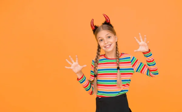 Ela é diabólica. Halloween festa menina fundo amarelo. Menina usar chifres vermelhos diabo cabeça. Menina misteriosa com olhar de Halloween. Menina pequena transformada em demônio ímpio — Fotografia de Stock