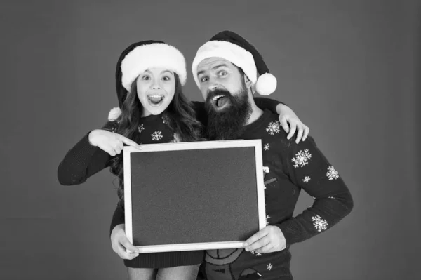 季節販売。クリスマス割引。ハッピーアワーのコンセプト。サンタ・クラスお父さんと小さな女の子が黒板を見せている。クリスマスの願い。ブラックボードの娘のコピースペース冬の販売。ショッピングシーズン — ストック写真