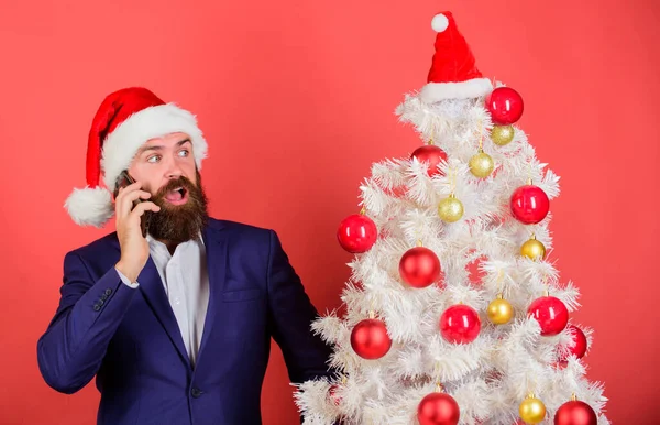 Udělat vánoční kouzlo s personalizované volání ze Santa. Vánoční hovor. Vytvořte Santa nazvat tyto Vánoce. Muž ve vousatém obleku a Santa klobouku drží telefon. Manažer blahopřeje kolegům mobilní hovor — Stock fotografie