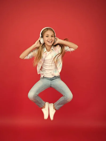 El chico hipster sigue moviéndose. baile infantil enérgico. Feliz infancia. inspirado en la música. vacaciones de primavera. chica celebrando la victoria. Niña pequeña con auriculares. diversión en movimiento. pequeña estrella de rock — Foto de Stock