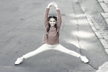 Bacak esneme antrenmanlarıyla esnekliği artırıyor. Küçük kız dışarıda antrenman yapıyor. Küçük çocuk bölme antrenmanı yapıyor. Antrenman yapıyorum. Beden eğitimi aktivitesi ve spor. Ayrılma rutini. Fitness, vintage filtre