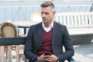 İş dünyasının yönetici müdürü açık kafedeki cep telefonunda günlük istirahat, telefon.