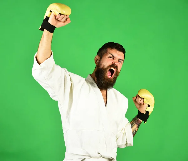 Karate man med argt ansikte i gyllene boxningshandskar. — Stockfoto