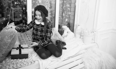 Sihirli an. İyi tatiller. Küçük kız açılış hediyesi. Yeni yıl. Noel Baba hediyesi. Küçük kız hediye aldı. Şimdiki Xmas. Hayaller gerçek olur. Evdeki çocuk rahat pencere pervazında dinleniyor.