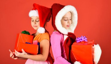 Heyecanlı yüzlü çocuklar sırt sırta durur.