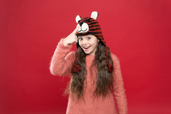 Усміхнена дівчина-підліток в затишному теплому одязі демонструє зимовий капелюх, в'язання — стокове фото
