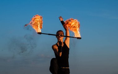 Her şey ışıltılarla ilgili. Seksi kadın ateş değnekleri çeviriyor. Mavi gökyüzünde kadın ateş sanatçısı. Kadın fakir dışarıda solo yapıyor. Sopa çevirme. Gece partisi. Tatil kutlaması