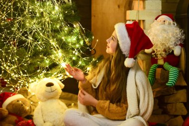 Noel Baba için. Işıklı Noel ağacı. Güzel ve rahat bir oda. Küçük kız yeni yılı bekliyor. Noel partisi başladı. Mutlu çocukluk. Bu kış gecesi aydınlık olacak. Çocuk oyuncağı hediyeleri. Noel ağacında Noel Baba çocuğu