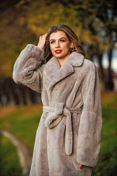 Een boetiek. Eenvoudig en warm. Een glamoureuze dame. Gezellige herfstoutfit. Winter modetrends. Luxe segment merk. Zachte jas harige textuur. Sexy vrouw rode lippen dragen bontjas. Zakenvrouw in bontjas — Stockfoto