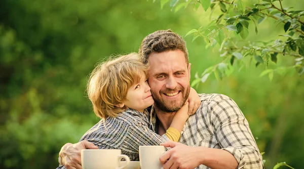 Develop healthy eating habits. Feed baby. Natural nutrition concept. Fathers day. Best friends. Father and son having fun. Feeding son natural foods. Healthy food. Father and boy drink tea outdoors
