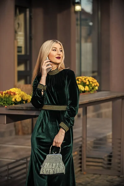 Modern life. girl care gem stone handbag or purse. glam clutch accessory. elegant woman in green velour dress. glamour velvet textile. sexy businesswoman speak on phone outdoor — Stock Photo, Image