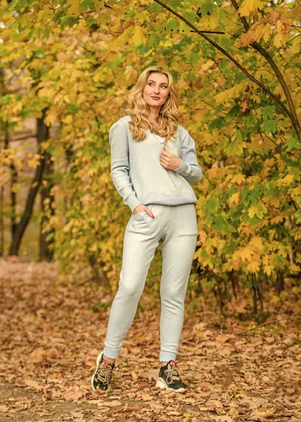 Full of life energy. knitwear clothes for fall season. Woman enjoy autumn season park. Girl relax nature fallen leaves background. Clothes for rest. cosy sport suit. Sporty girl. wear comfort clothes