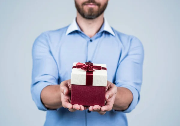 Ongeschoren man bijgesneden bekijken geschenk doos gebonden met rood lint strik selectieve focus, boksdag — Stockfoto