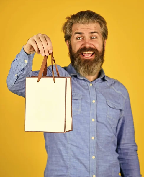 Compras bem sucedidas. presentes. Encantado homem fazendo compras online. Extremamente feliz hipster fazendo compras na loja de eletrônicos. Um homem positivo a gostar de fazer compras. Assuntos próprios. homem barbudo segurar saco de papel — Fotografia de Stock