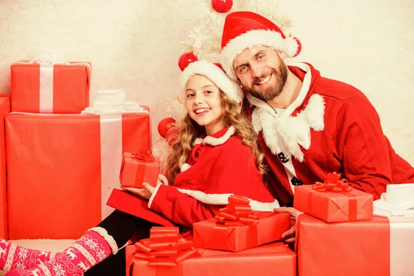 Papá disfrazado de Papá Noel regala a su hija un lindo niño. Feliz infancia. Vacaciones familiares de Navidad. Haz que tus vacaciones infantiles sean especiales este año. Concepto de Papá Noel. Regalo de Navidad para niño — Foto de Stock