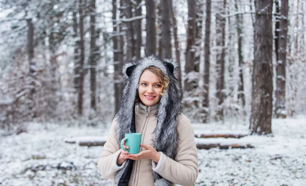 Animal care. Winter themed portrait cosy outfit. Woman wear wolf hat. Animal rights. Wild life symbol. Girl in snowy forest. Faux fur animal hat perfect for fantasy theme. Heartwarming concept