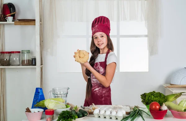 Ingrédient préféré. développement de l'enfance. petite fille cuisson dans la cuisine. petit chef cuisinier faisant de la pâte. enfant préparer des aliments sains à la maison et porter un uniforme de cuisinier. ménage et aide à domicile — Photo