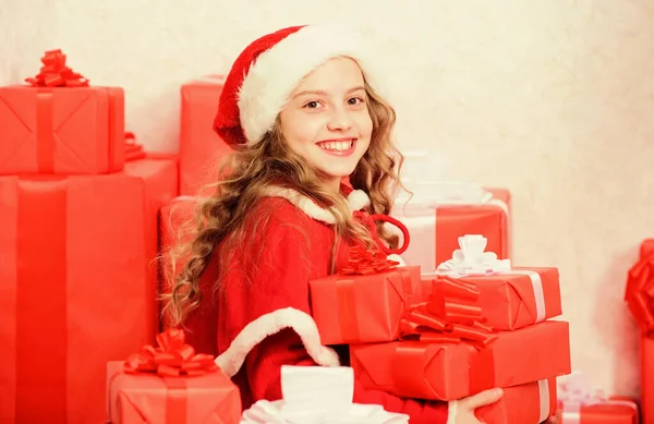 Auspacken des Weihnachtsgeschenks. Kind freut sich auf Weihnachtsgeschenk. Mädchen feiern Weihnachten. Kind hilft Weihnachtsmann. Neujahrsfeiertag Tradition. Little Santa Helper Konzept. Weihnachtsgeschenke erkunden — Stockfoto