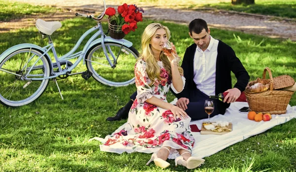 First Date Ideas Guaranteed to Win Her Heart. Enjoying their perfect date. Happy loving couple relaxing in park with food. Romantic picnic with wine. Couple in love picnic date. Spring weekend