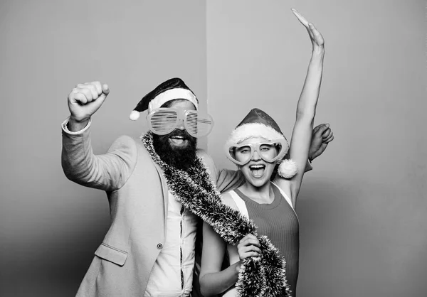 Χειμερινό εταιρικό πάρτι. Χριστουγεννιάτικο πάρτι γραφείου. Ευτυχισμένος άντρας και γυναίκα φορούν καπέλα Σάντα και αστεία γυαλιά ηλίου. Ο διευθυντής Τίνσελ γιορτάζει την Πρωτοχρονιά. Χριστουγεννιάτικο πάρτι. Εταιρικές ιδέες για πάρτι διακοπών — Φωτογραφία Αρχείου