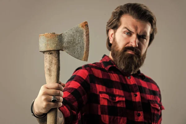 Lenhador com uma camisa xadrez. Homem barbudo brutal Lumberjack em camisa quadriculada vermelha. conceito de barbear. Dia das Bruxas. O homem tem um machado na mão. Lenhador barbudo com um machado. foco seletivo — Fotografia de Stock