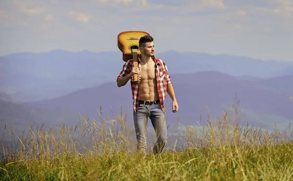 A melhor maneira de escapar da cidade. Ar fresco de montanha. Destinos de férias. Caminhar sozinho. Homem com guitarra a andar no topo da montanha. Cara caminhante desfrutar da natureza pura. Explorando a natureza. Beleza da natureza — Fotografia de Stock